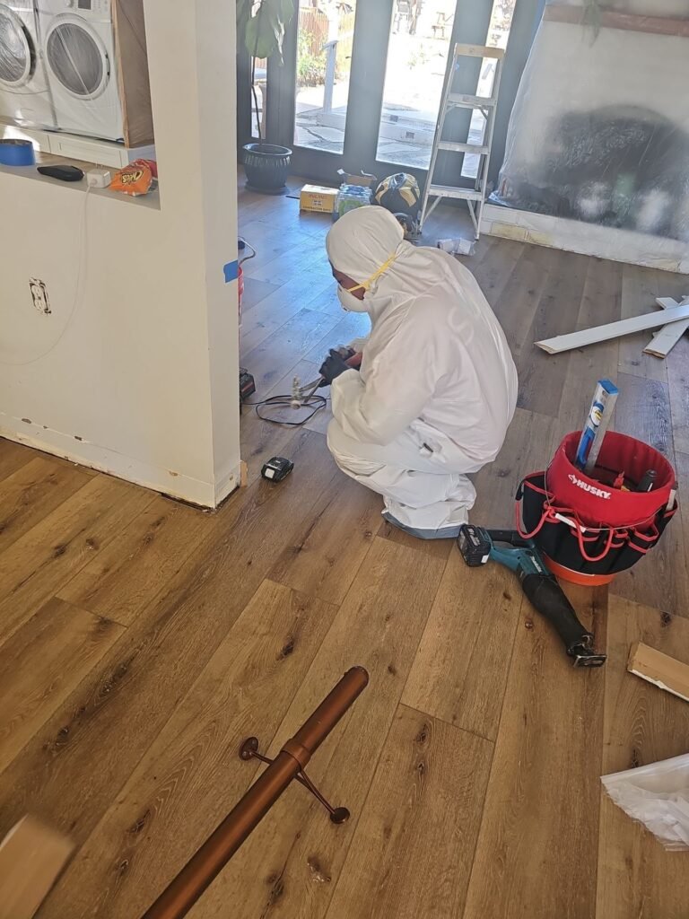 Technician extracting water from a hardwood floor in a Santa Ana home