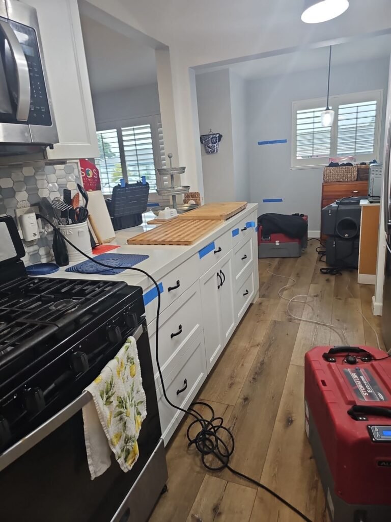 Kitchen cabinets opened and drying equipment running in a Santa Ana home
