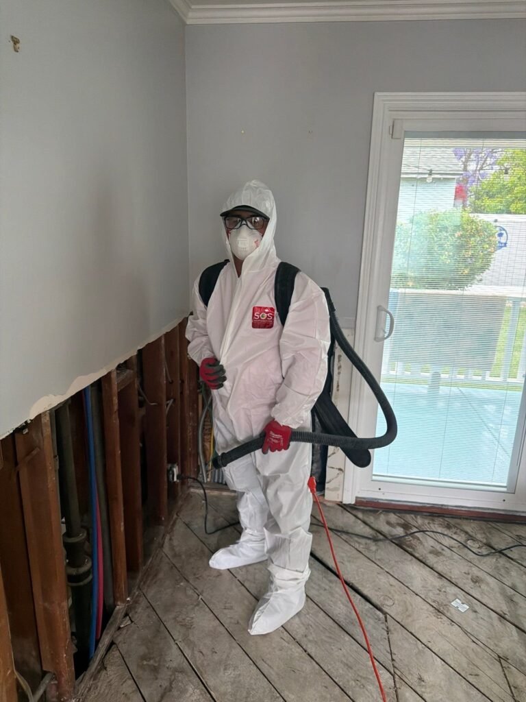 Technician working an opened wall as a Santa Ana drying job finishes