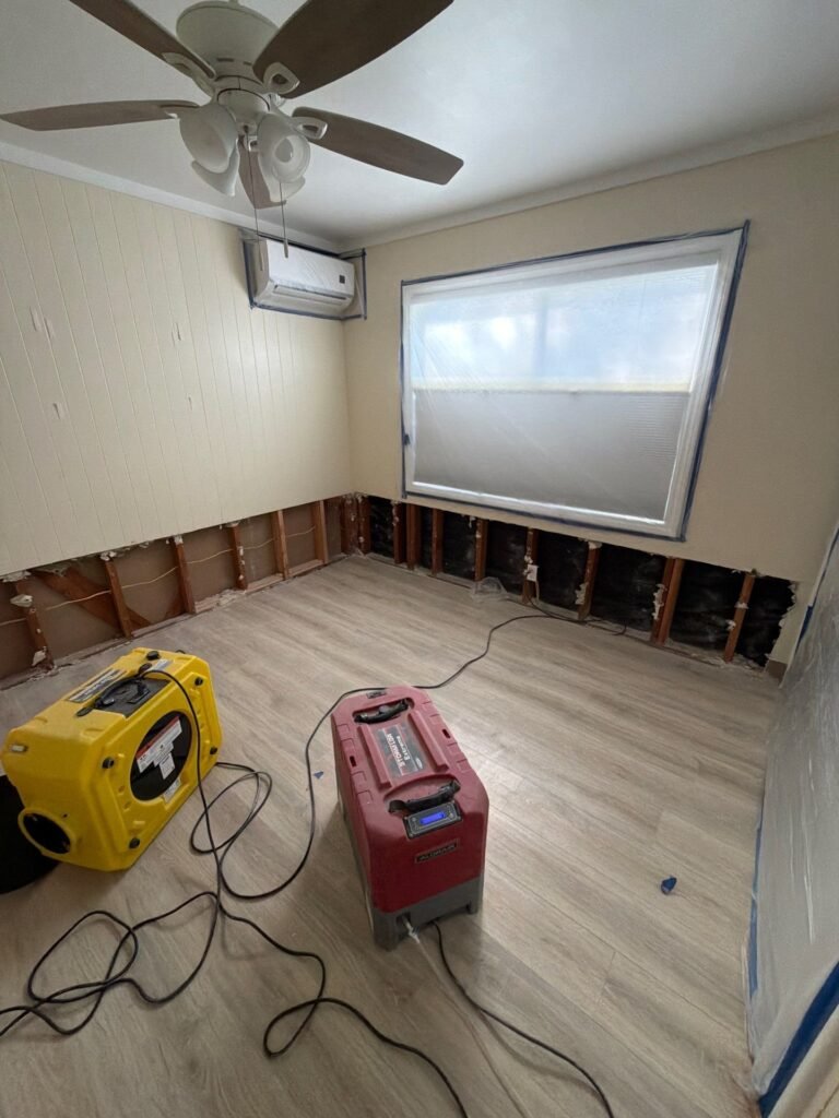 Baseboards removed and air movers running in a Santa Ana room